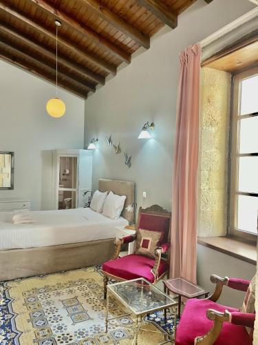 a bedroom with a bed and a table and chairs at Erietta Suites in Chania