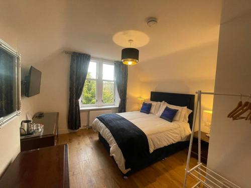 Schlafzimmer mit einem Bett und einem Fenster in der Unterkunft Crannach House in Ballater
