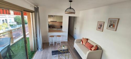 un salon avec un canapé et une cuisine dans l'établissement Studio belle terrasse 2min des plages, à Cannes