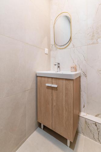 une salle de bain avec un lavabo et un miroir dans l'établissement Flat Rue d'Assas private garden, à Paris