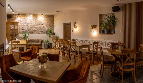 ein Restaurant mit Tischen und Stühlen und einer Ziegelwand in der Unterkunft Forteca, pokoje gościnne nad stawem in Dzierżoniów