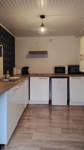 une cuisine vide avec des armoires et des appareils blancs dans l'établissement Maison de l'harmonie à Limoges, à Limoges