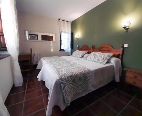 um quarto com uma cama e uma parede verde em La Casa Solariega em Santillana del Mar
