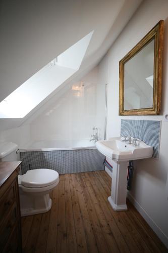 a bathroom with a sink and a toilet and a mirror at Villa Joséphine 4-11 personnes in Asnelles