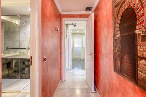 a hallway with a red wall and a door at Hanami Alcazaba Beach Duplex Sea View in Estepona