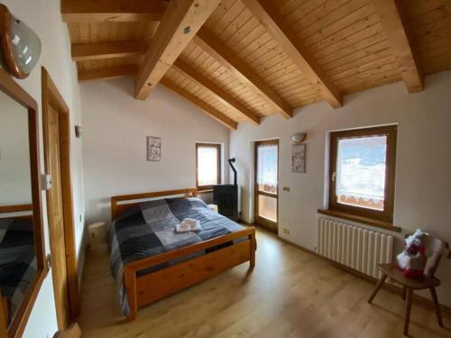 ein Schlafzimmer mit einem Bett in einem Zimmer mit Holzdecken in der Unterkunft Appartamento da Fabio - nel cuore delle Dolomiti in Danta