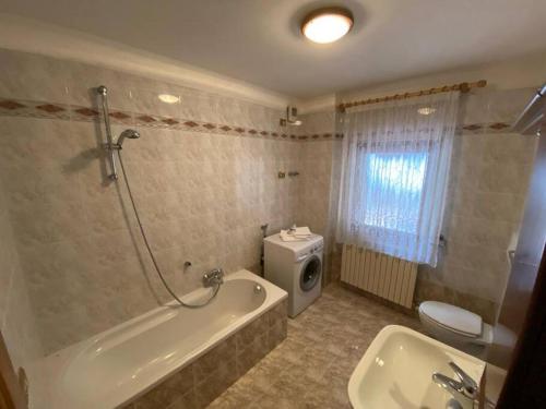 ein Badezimmer mit einer Badewanne, einem WC und einem Waschbecken in der Unterkunft Appartamento da Fabio - nel cuore delle Dolomiti in Danta