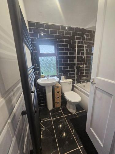 een badkamer met een toilet en een wastafel bij Quiet family home in Tettenhall