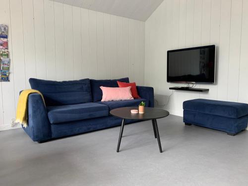 een woonkamer met een blauwe bank en een tafel bij De Woudvaart Sneek in Sneek