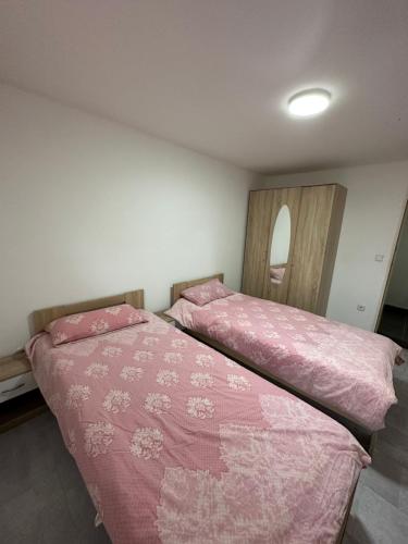 2 camas en un dormitorio con mantas rosas y espejo en Charmante 2 Zimmer Souterrain en Hannover