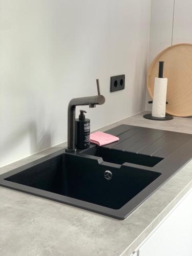 a black kitchen sink with a faucet on a counter at De Woudvaart Sneek in Sneek