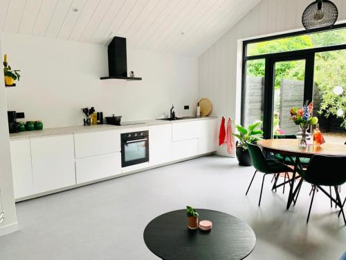 a kitchen with white cabinets and a table at De Woudvaart Sneek in Sneek