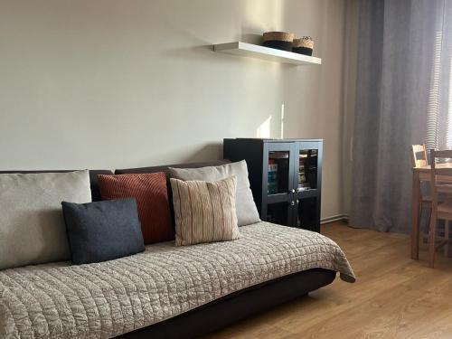 a couch with pillows on it in a living room at Apartament Śródmieście Krosno in Krosno