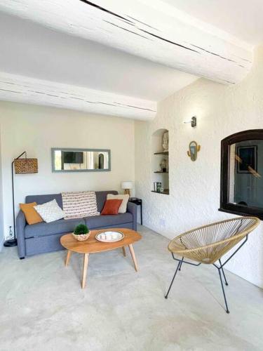 un salon avec un canapé bleu et une table dans l'établissement L'Olivier - Clim - Terrasse, à Cassis