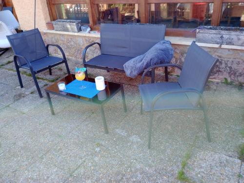 a group of three chairs and a table with a blanket on it at Finca Arroyo del Valle NO HAY PISCINA in San Andrés del Rabanedo
