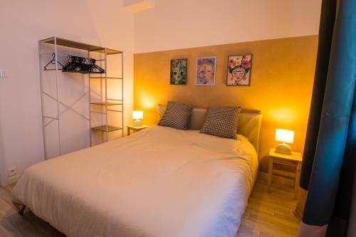 ein Schlafzimmer mit einem weißen Bett mit zwei Lampen in der Unterkunft Hesdin Appart Holidays 1 in Hesdin