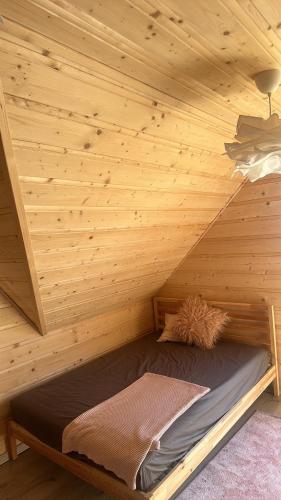 a wooden cabin with a bed in a room at Siedlisko Huta Szklana in Bieliny