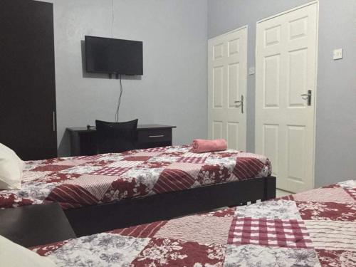 1 Schlafzimmer mit 2 Betten und einem Flachbild-TV in der Unterkunft Stone Terrace Lodge in Nkhotakota