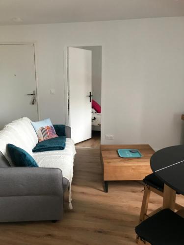 un salon avec un canapé et une table dans l'établissement Location saisonnière type 2 4 personnes, à Fouesnant