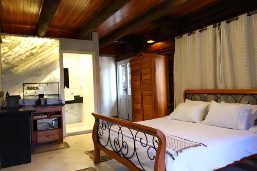 a bedroom with a large bed and a window at Aldeia Flor de Liz - Pedra Azul in Pedra Azul