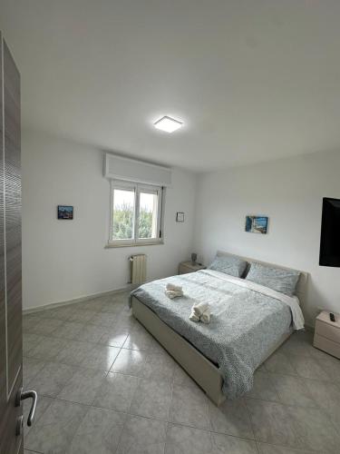 een witte slaapkamer met een bed en een raam bij Antonio's Home in Bari
