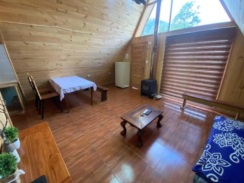 Sala de estar con mesa, banco y sidx sidx sidx de mesa en Cabaña Ataraxia (RDS), en Riñinahue