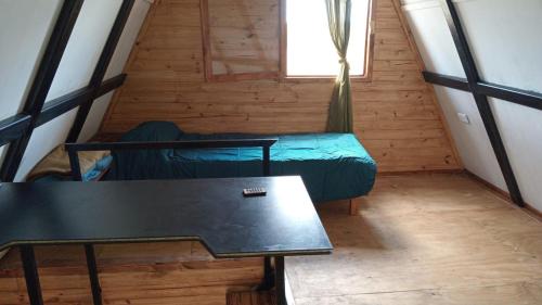Habitación con mesa, cama y ventana en La Alpina en Panaholma