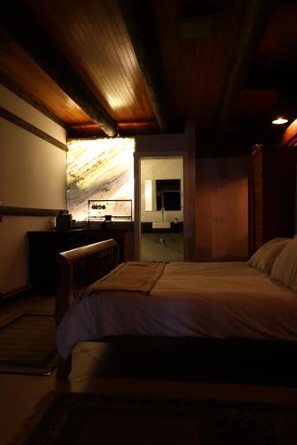 a bedroom with a bed and a window with a microwave at Aldeia Flor de Liz - Pedra Azul in Pedra Azul