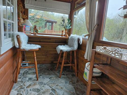 a room with two stools in front of a window at 299 Willow Lodge in Trawsfynydd