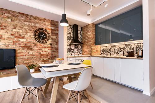 kuchnia ze stołem i krzesłami oraz ceglaną ścianą w obiekcie City Centre Modern Apartment Poznań Free Parking w Poznaniu