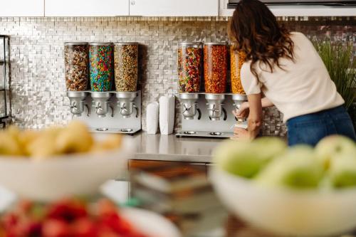 a woman standing in a kitchen looking at some food at San Francisco Marriott Marquis Union Square in San Francisco