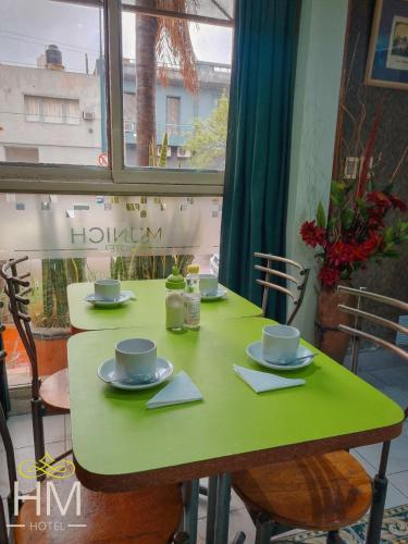 a green table with cups and saucers on it at HOTEL HM in Córdoba