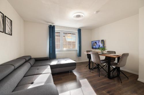 a living room with a couch and a table at ADN Suites - NETFLIX - modern and smart in Günzburg