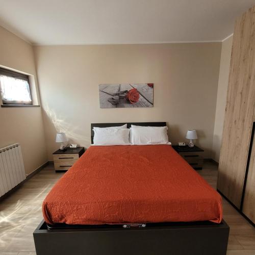 Un dormitorio con una cama con una colcha roja. en Villa Dall'Angelo Suite Mountain Lake Endine Hospitality, en Endine Gaiano