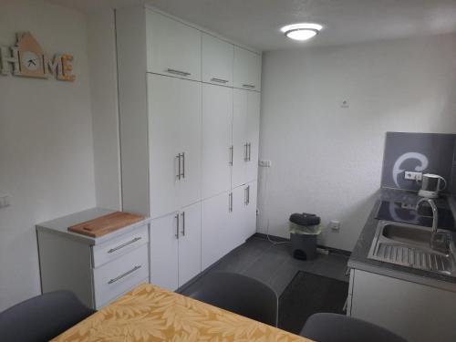 a kitchen with white cabinets and a table and a sink at The Bosna River in Vreoca