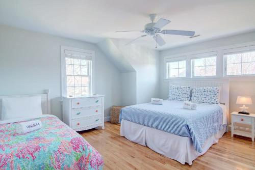 a bedroom with two beds and a ceiling fan at Walk to Oyster Pond and Main Street Chatham in Chatham
