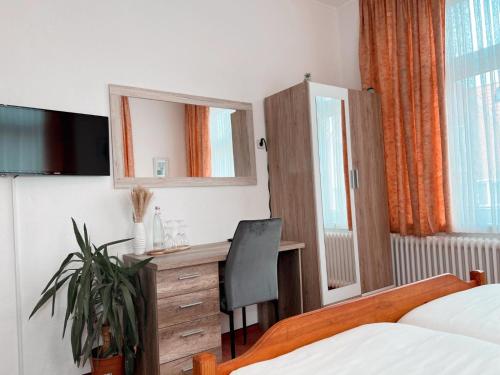 a hotel room with a desk and a bed at Dions Rooms in Norderney