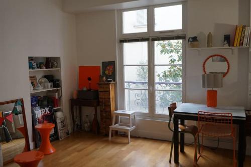 - un salon avec une table et une fenêtre dans l'établissement Double appartement - Le Marais, à Paris