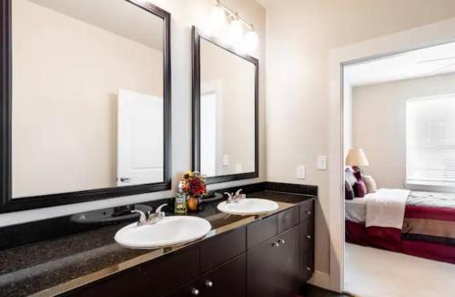 La salle de bains est pourvue de 2 lavabos et de 2 miroirs. dans l'établissement Your 1Br and LR Home Away From Home, à Dallas
