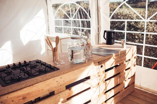 a kitchen with a stove and a window at The Glamping Spot - Douarnenez in Plonévez-Porzay
