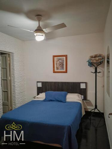 1 dormitorio con 1 cama con manta azul en HOTEL HM en Córdoba