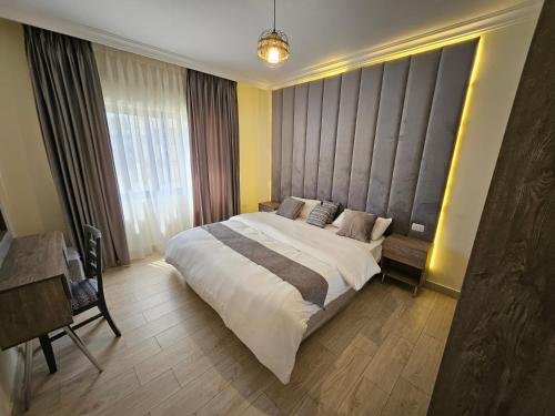 - une chambre avec un grand lit et une fenêtre dans l'établissement مجمع الحدائق, à Amman