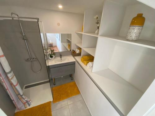 baño blanco con ducha y lavamanos en Lagon privé du Diamant, en Le Diamant