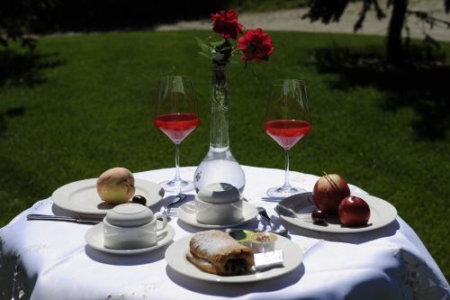 a table with plates of food and two glasses of wine at Hotel Garni Pegrà in Ponte di Legno