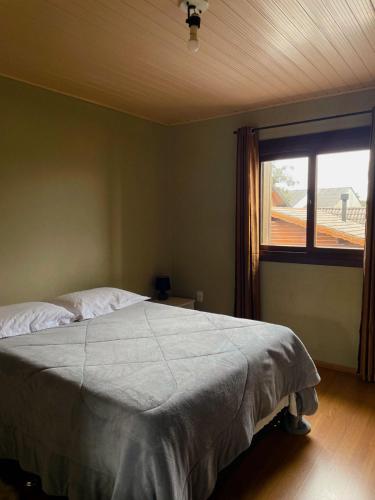 a bedroom with a large bed and a window at Família Cavalli in Gramado