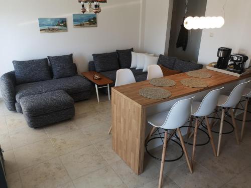a living room with a table and a couch at Απέραντο γαλάζιο Le grand blue in Mola Kalyva