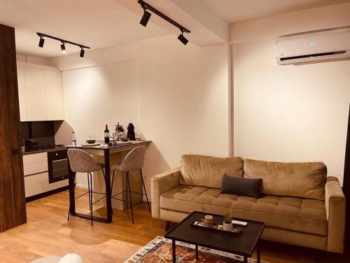 a living room with a couch and a table at Central Apartment Prishtina in Pristina