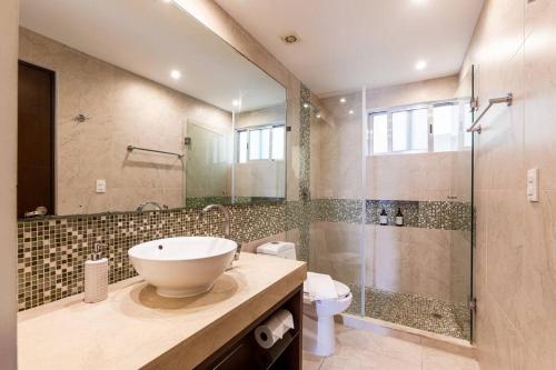 a bathroom with a sink and a shower at Skyline by Zama Homes in Playa del Carmen