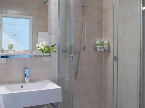 bagno con doccia in vetro e lavandino di VISIONAPARTMENTS Chemin des Epinettes - contactless check-in a Losanna