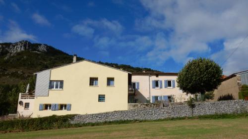 ein großes weißes Haus mit einer Steinmauer in der Unterkunft Infocus-Du-Sud in Soula